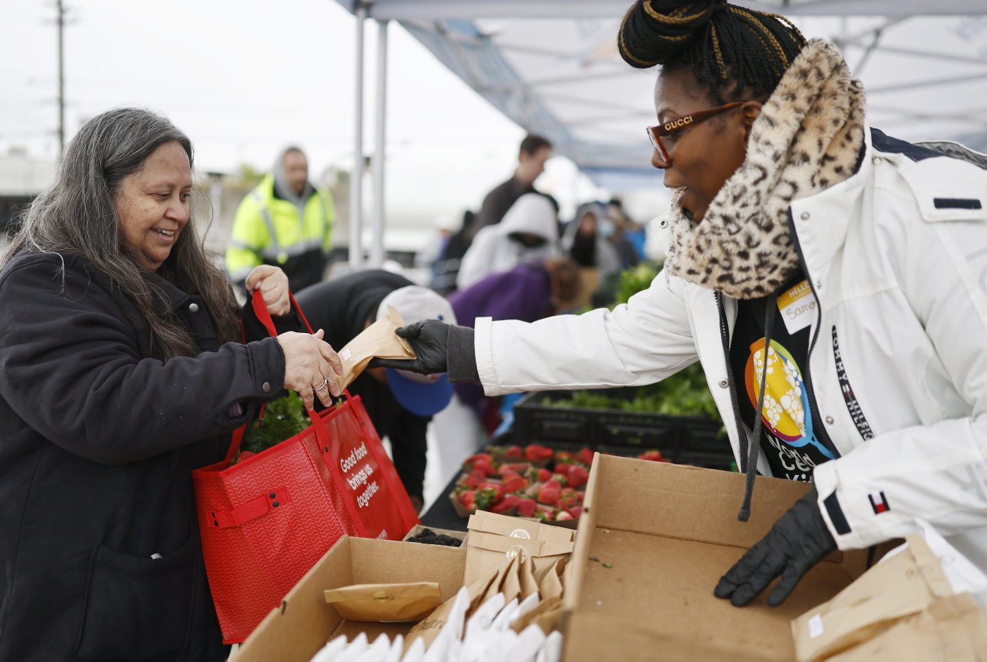 ALTADENA, CALIFORNIA - MARCH 14: A volunteer (R) passes out free cookies as community members receive free produce near World Central Kitchen&#039;s new Rapid Response Mobile Kitchen near the Eaton Fire burn zone on March 14, 2025 in Altadena, California. The 43-foot-long truck can produce up to 20,000 meals a day to disaster-impacted communities and was on its first disaster response cooking mission today in Altadena. (Photo by Mario Tama/Getty Images)